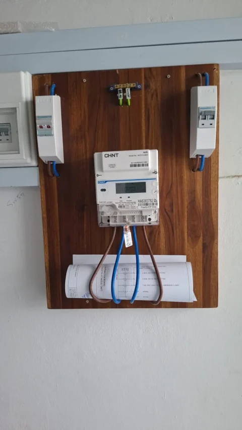 Completed timber meter board by Best Volt, with a CHNT smart meter centred between isolators, an earth bar above, and the board drawing below, on an SP Group meter installation.