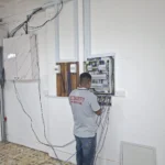 Meter-board position inside the unit, blue trunking on the wall and cables on the floor beside a marble cabinet, during a Best Volt SP Group meter installation.