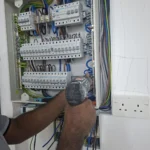 Close-up of distribution-board termination by Best Volt, impact driver at the MCB row, cables labelled L1P1 and a socket marked L2P4.