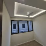 Finished bedroom cove ceiling by Best Volt, with a ceiling fan, downlights, and a three-panel window in a Singapore condominium.