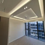 Cove lighting on before final fix, cable still out at the corner and an air-con indoor unit in frame, during a Best Volt bedroom lighting install.