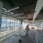 Cable drops on the same office floor before the ceiling closed, glass facade behind, during a Best Volt lighting fit-out.