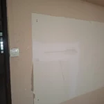 Hand-drawn light and fan layout on a wall beside a three-gang switch and a gypsum patch, a Best Volt lighting-layout planning frame.