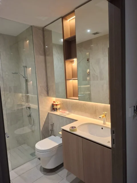 Luxury bathroom by Best Volt, glass shower, wall-hung WC, timber vanity, and a warm LED niche in the mirror cabinet.