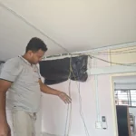 Air-con indoor unit still wrapped, yellow, blue, and earth cables out, during an air-con power connection by Best Volt in an older flat.