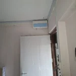 Cm emergency light mounted above a door, blue LED panel beside it, installed by Best Volt.