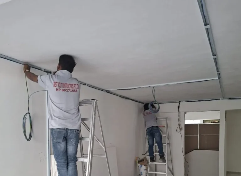 Electrician assessing electrical wiring in a Singapore home